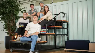 Fuenf Auszubildende und Studierende sitzen auf einer Treppe