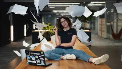 Junge Auszubildende mit Laptop im modernen Workspace