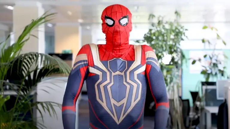 Person im Spider-Man-Kostüm steht mit verschränkten Armen in einem modernen Büro bei Bosch Home Comfort Group.