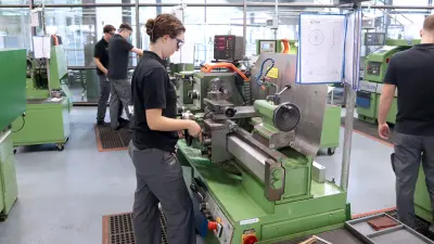 An einer Drehmaschine lernt eine Auszubildende der Mechatronik bei Bosch den Umgang mit einer Fräsmaschine.