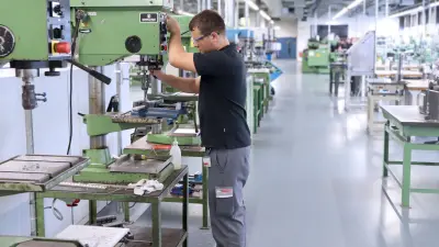 Ein Auszubildender bei Bosch lernt die wichtigsten Handgriffe an einem Tischbohrmaschine.