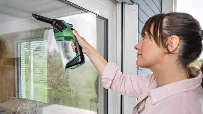 Ein Testimonial reinigt eine Fensterscheibe mit einem Bosch-Produkt