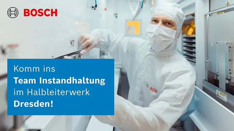 Vier Personen stehen an einem hohen Holztisch in einem modernen Büro, unterhalten sich und lächeln.
