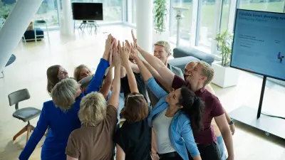 Eine Gruppe von Menschen gibt sich gleichzeitig ein High-Five