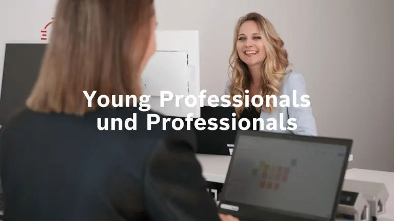 Zwei Personen sitzen zusammen an einem Tisch und besprechen sich.