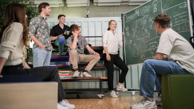 Sechs Jugendliche sammeln Ideen auf einer Tafel