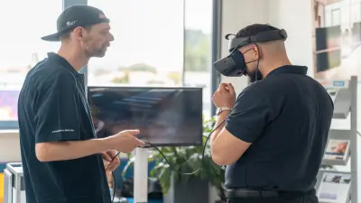 Zwei Maenner in Boschkleidung testen eine VR-Brille