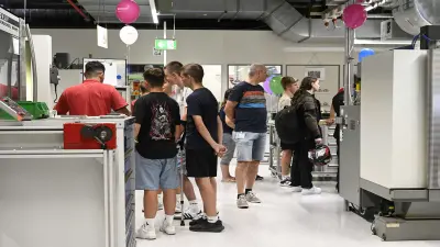 Jugendliche in Freizeitkleidung in einer Werkstatt