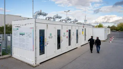 Containerbasierter Prüfstand für Brennstoffzellen mit zwei Personen im Außenbereich.