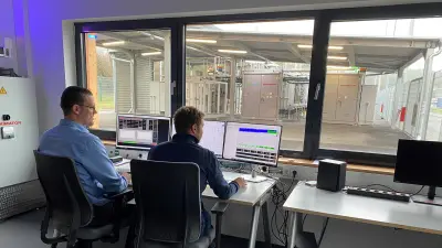Leitstand mit Arbeitsplätzen und Blick auf technische Anlagen im Testfeld.