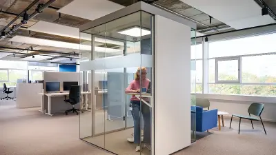 Bürofläche mit höhenverstellbaren Tischen und Telefonboxen