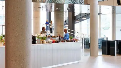 Zwei Mitarbeiteder der Firma Bosch stehen sich an einer Caféteria gegenüber und unterhalten sich