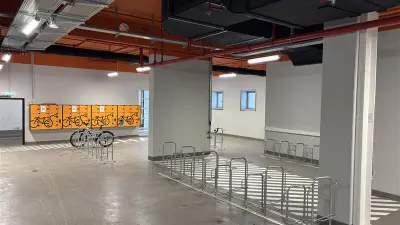 Moderner Fahrradraum im Keller eines Bürogebäudes mit Fahrradständern, Schließfächern und heller Beleuchtung