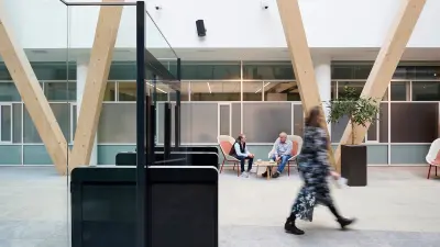 Eingangsbereich mit Zugangsschranke durch die eine Person läuft 