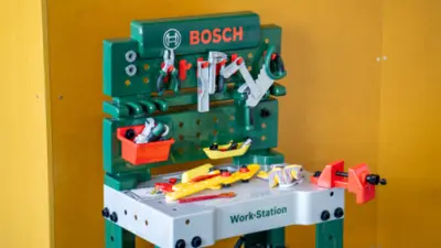 Ein grünes Kinder‑Werkstattspielzeug mit Bosch‑Branding steht aufgebaut da.