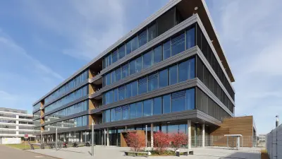 Außenansicht von einem modernen mehrstöckigen Bürogebäude auf dem Bosch eBike Systems eCampus in Kusterdingen, dessen Fassade beinahe gänzlich aus Glas besteht.