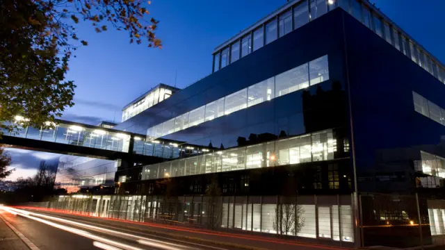  Ein modernes Bürogebäude in Reutlingen mit erleuchteten Fenstern bei Nacht.