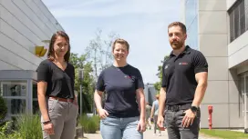 Chiara (links), Verena (Mitte) und Kevin (rechts) unterhalten sich vor dem Bosch-Gebäude und laufen auf die Kamera zu.