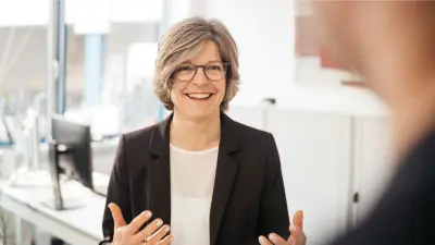 Frau Marion Oertel-Nau gestikulierend und lachend im Gespräch.