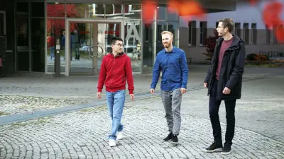 Christoph Dörr läuft gemeinsam mit zwei Kollegen vor einem Bosch-Gebäude. Sie unterhalten sich.