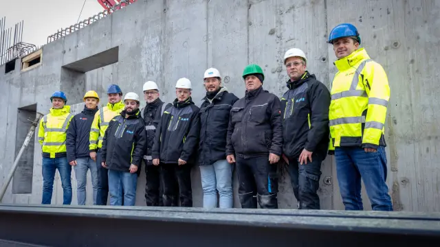 Gruppenbild mit zehn insgesamt zehn Personen von Bosch Power Tools und Anes Bau vor dem Rohbau des Estrel Towers.