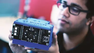 Das Bild zeigt einen Bosch Mitarbeiter mit dem Bosch-Sensorsystem SoundSee. Soundsee war bereits auf der Internationalen Raumstation ISS im Einsatz. Mithilfe von Mikrofonen und maschinellem Lernen werden Geräusche aufgezeichnet und analysiert. Soundsee interpretiert diese Daten und nutzt sie zur Verbesserung des ISS-Betriebs.