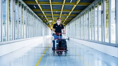 Lara Wehrmeister fährt mit einem Roller im Flur, frontal in Richtung Kamera. 