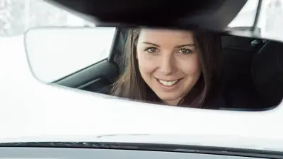 Frau am Steuer mit Laptop
