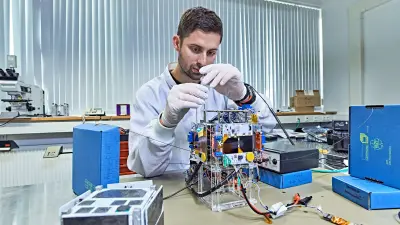 Ein Student arbeitet an dem Mini-Satellit.