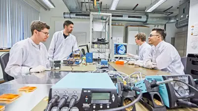 Vier Studenten arbeiten an einem Labortisch.