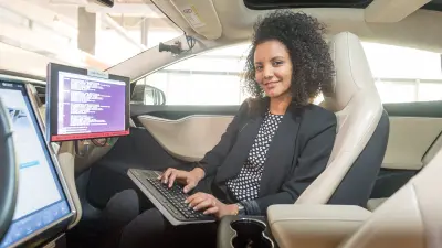 Frau arbeitet im Auto an automatisiertem Fahren